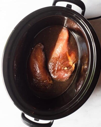 a raw, thawed freezer meal in a slow cooker sitting on a marble surface